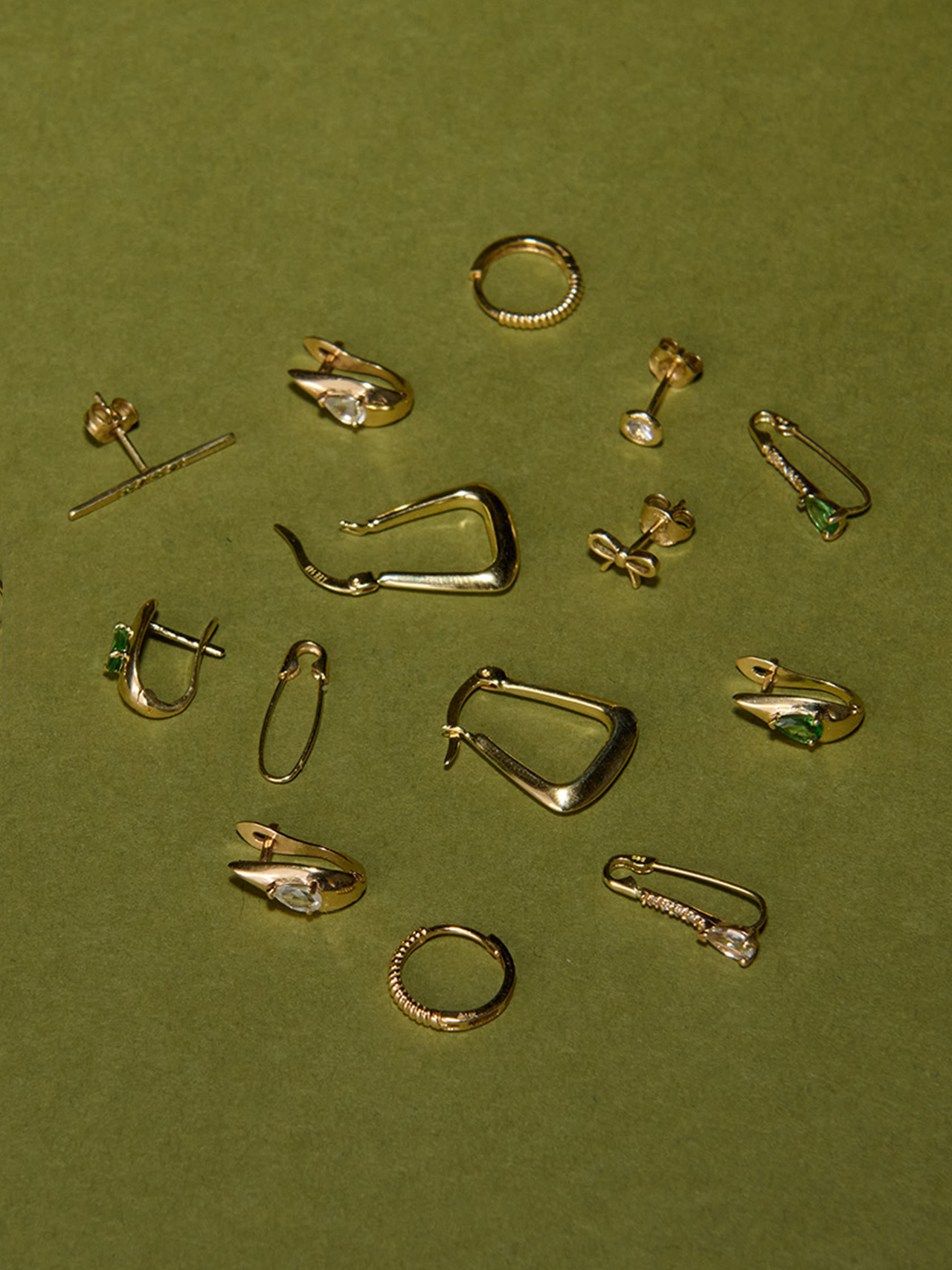 14kt Yellow Gold Gemstone Serpent Huggies pictured in multi-product flat lay.