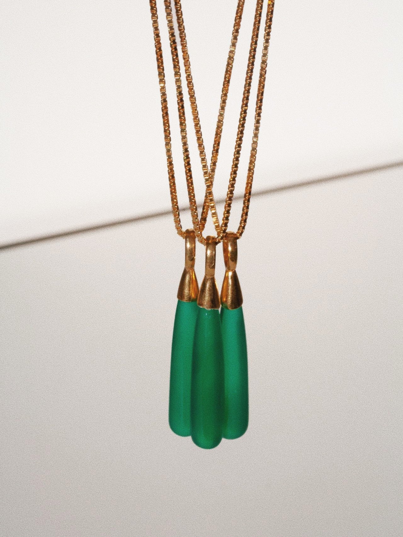 Three Stone Teardrop Necklace pictured dangling. 