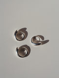 Three Ouroboros Ring pictured on light grey background. Birds eye view angle. 