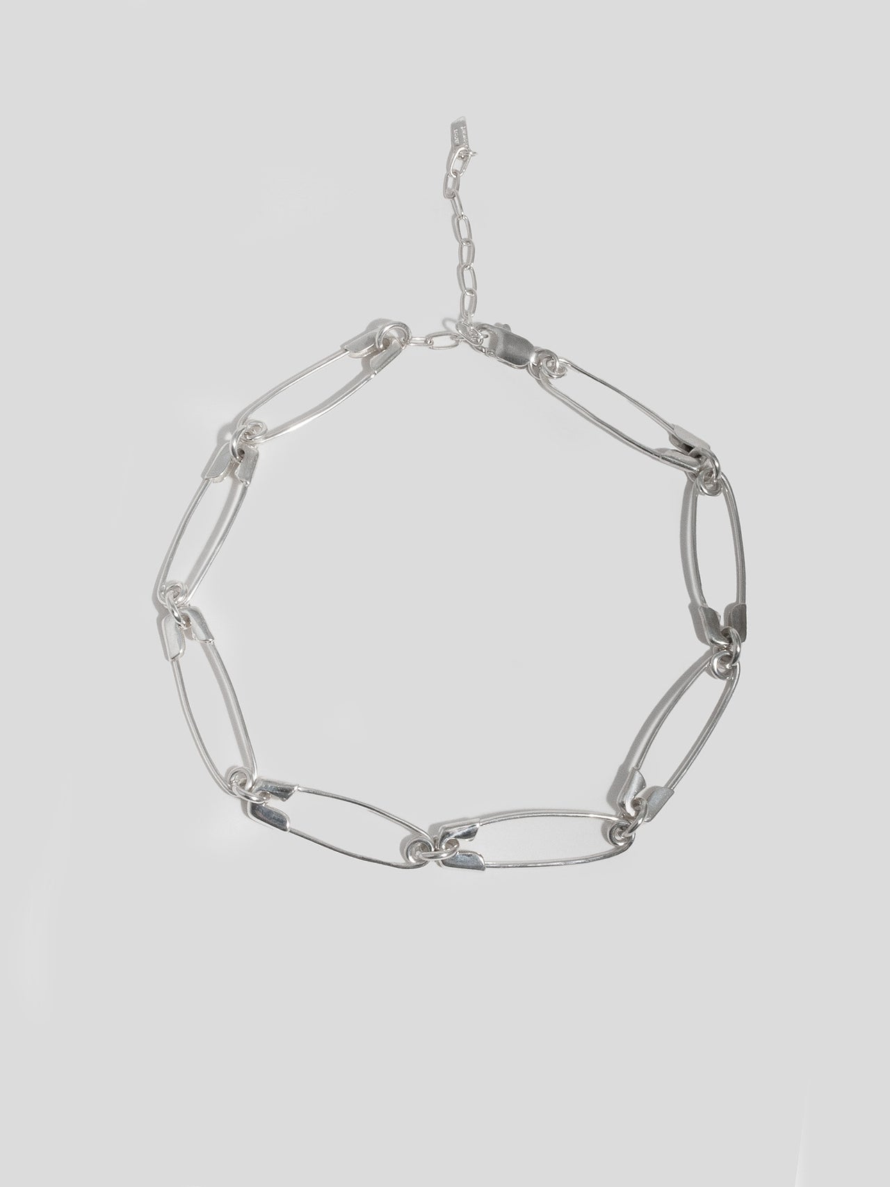 Sterling Silver Safety Pin Link Chain pictured on light grey background. 