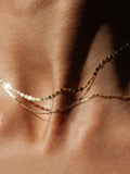 Baby Sol Valentino Necklace layered with the Standard Sol Valentino necklace on models neck. Close up shot.