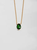 14kt Yellow Gold Oval Gemstone Necklace close up on light grey background. 