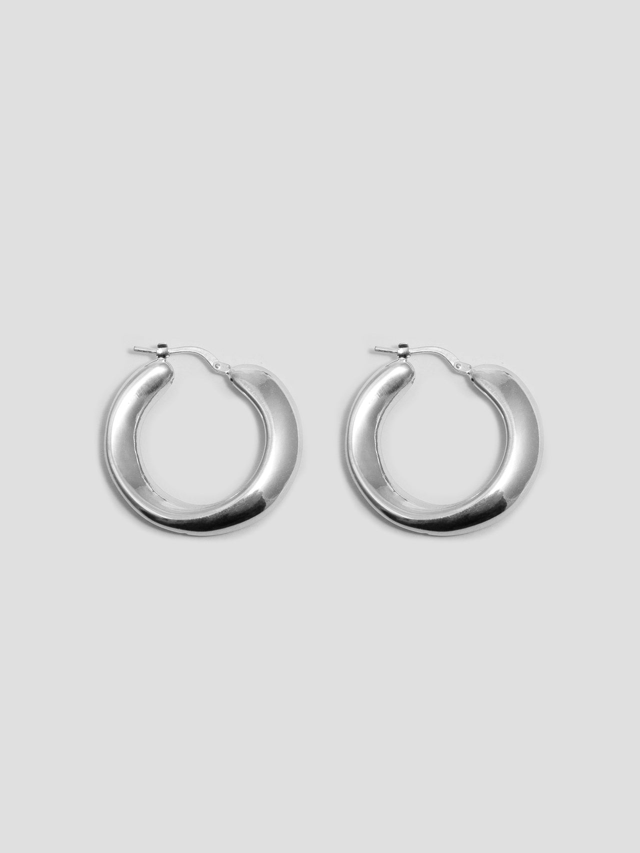 Sterling Silver Pli Hoops pictured on light grey background.