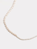 Close up of 14kt Yellow Gold Graduated Pearl Necklace pictured on light grey background.