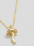Close up of yellow gold mushroom pendant on yellow gold chain. 