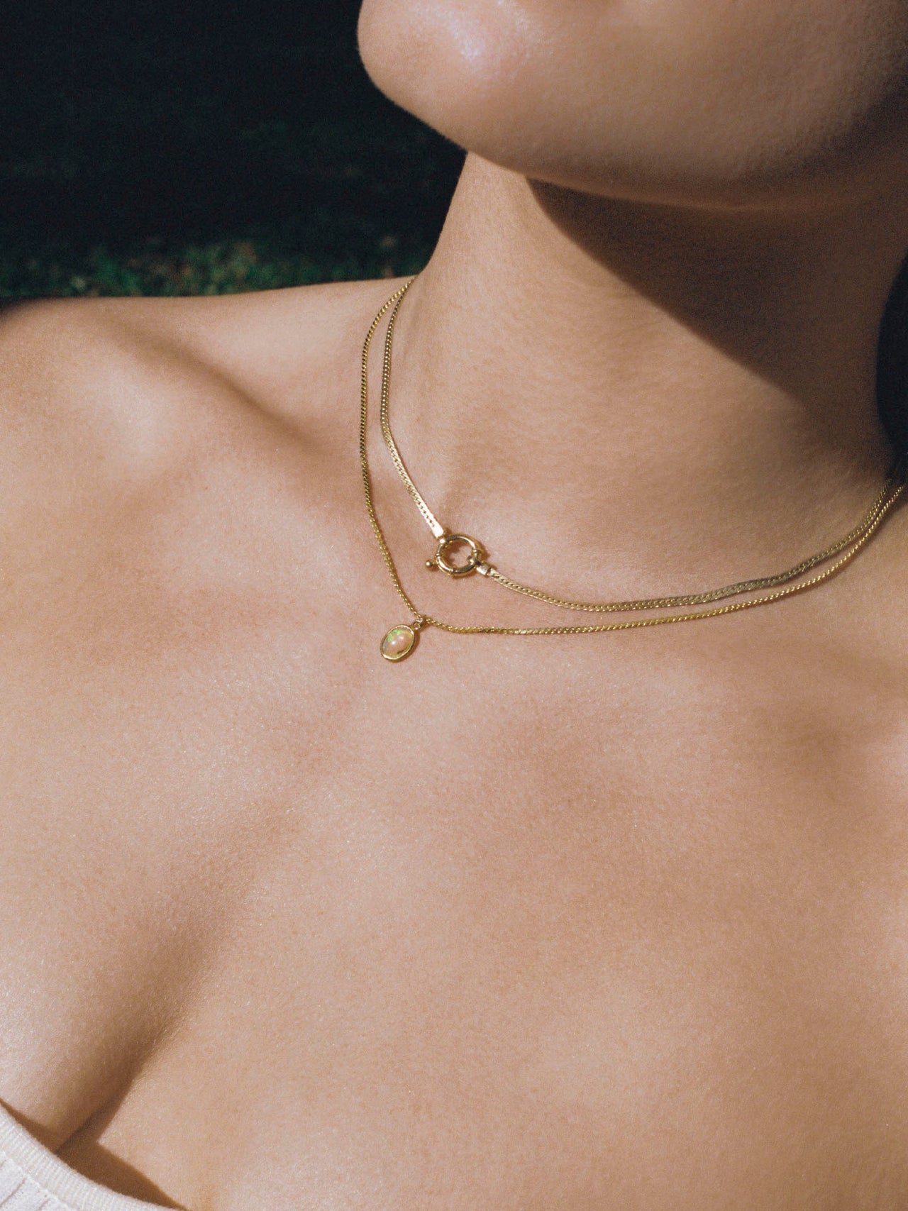 Close up on model image of the Chevron Necklace on neck (Shiny Gold Vermeil 2.3mm Wide Herringbone Chain 16.5" Length) Background: Grey backdrop